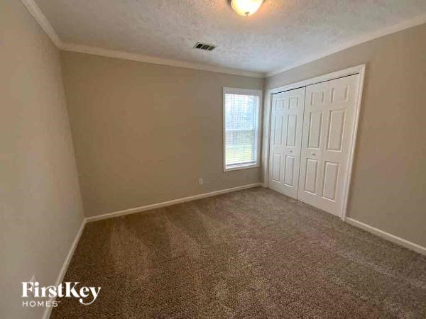 A room with a carpeted floor and a white door.