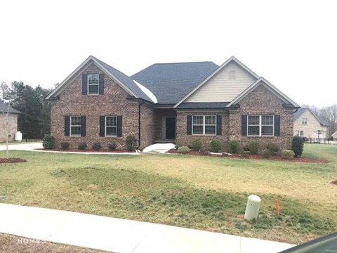 a brick house with a yard in front of it