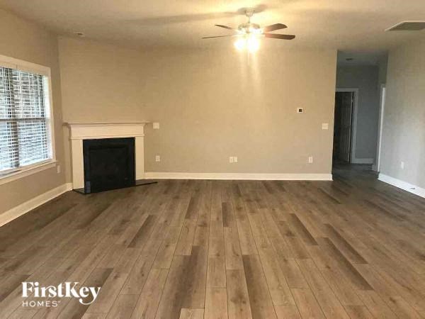 an empty living room with wood floors and a fireplace