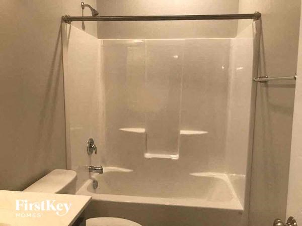 a white bathroom with a shower and a toilet