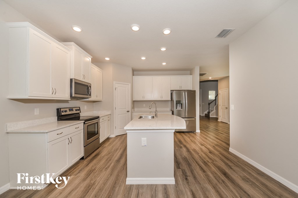 a kitchen with white cabinets and stainless steel appliances