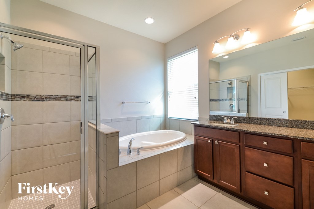 a bathroom with a tub and a shower and a sink