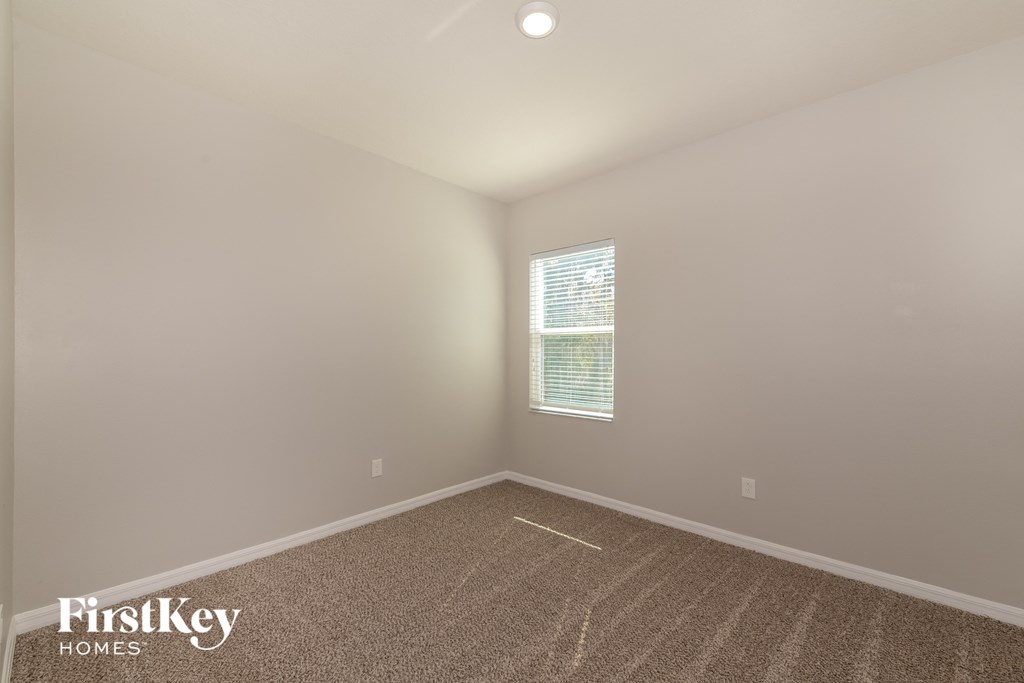 an empty room with carpet and a window