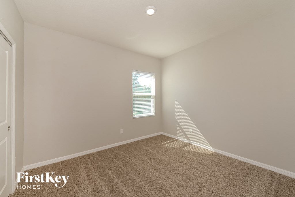 an empty room with carpet and a window