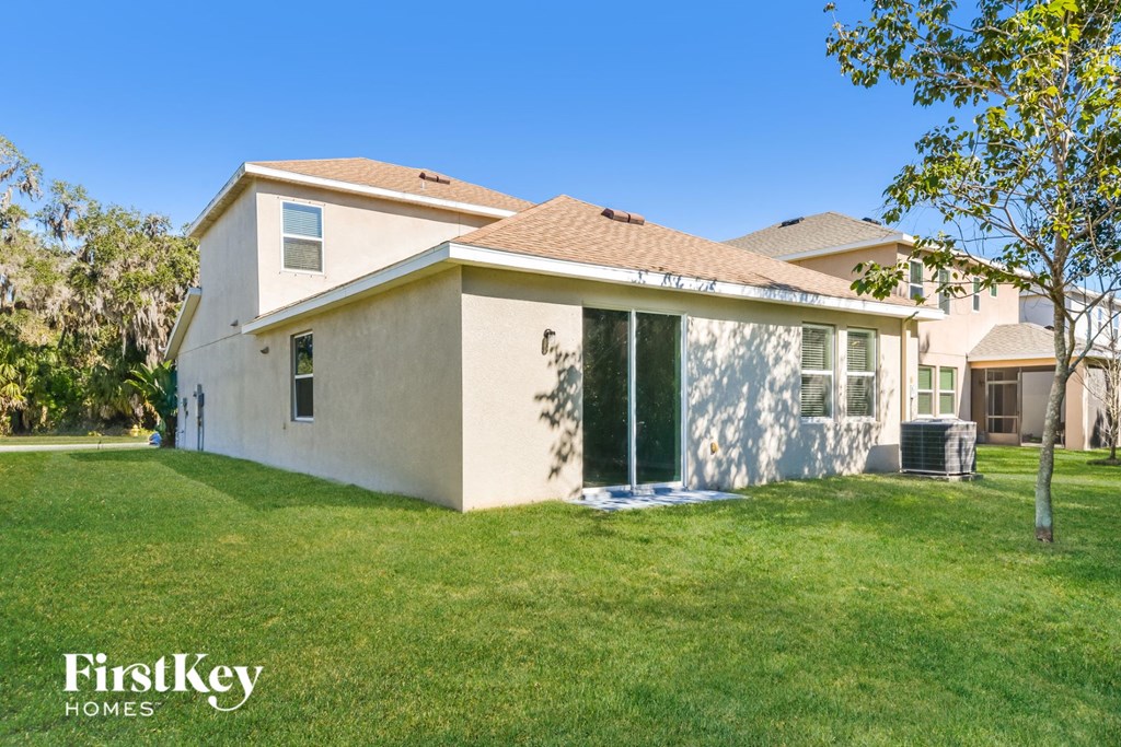 a white house with a lawn and a tree