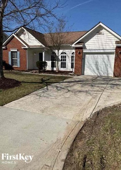 A brick house with a white garage door and a driveway.