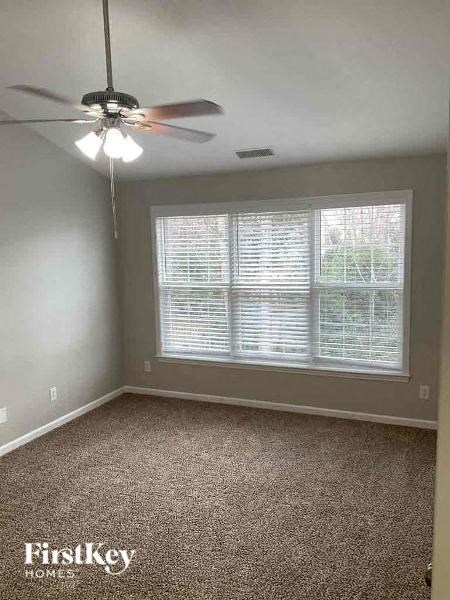 an empty room with a ceiling fan and a large window