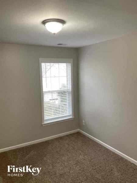 an empty room with a window and a carpet