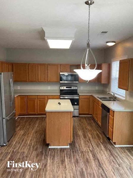 a kitchen with wood flooring and stainless steel appliances