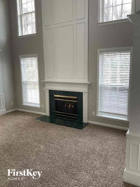 a living room with a fireplace and three windows