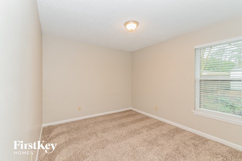 a bedroom with a carpeted floor and a large window