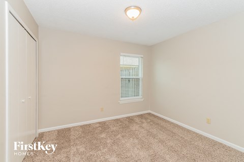 a spacious room with carpet and a window