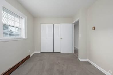 A room with a grey carpet and white walls.