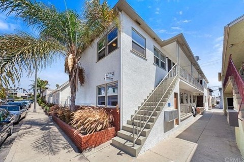 a building with a staircase and a palm tree in front of it