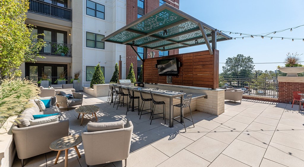 a patio with a bar and seating area with chairs and tables