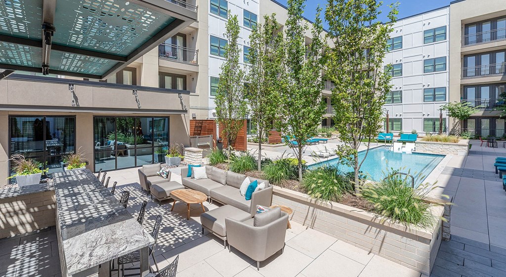 a patio with couches and chairs and a pool