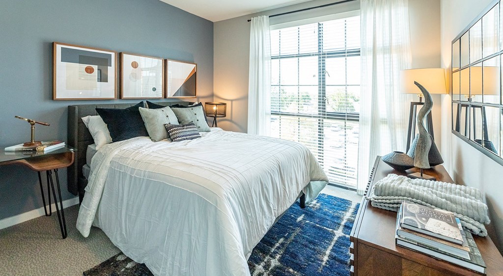 a bedroom with a bed and a large window