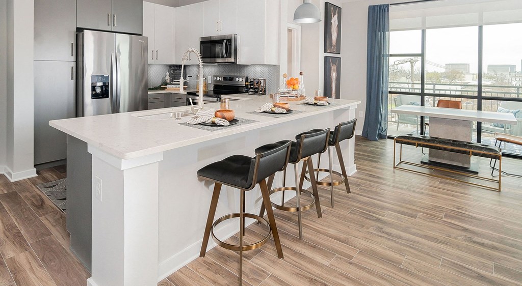 a kitchen with a large island with bar stools