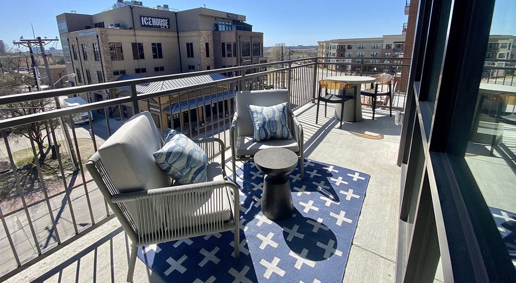 a patio with chairs and a table on a balcony