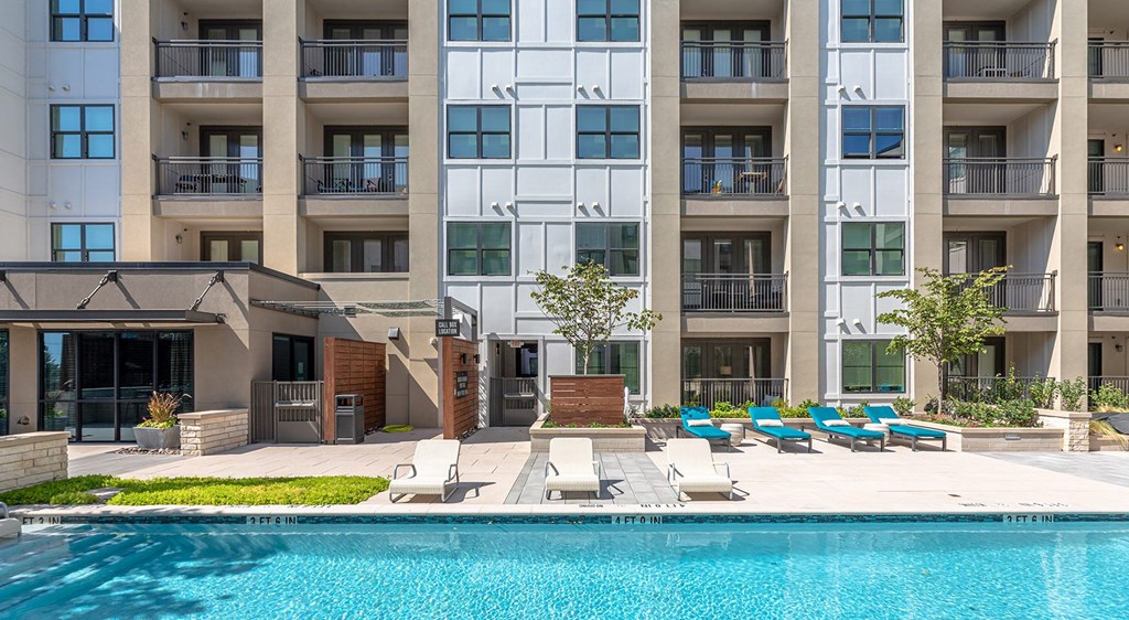a swimming pool in front of an apartment building