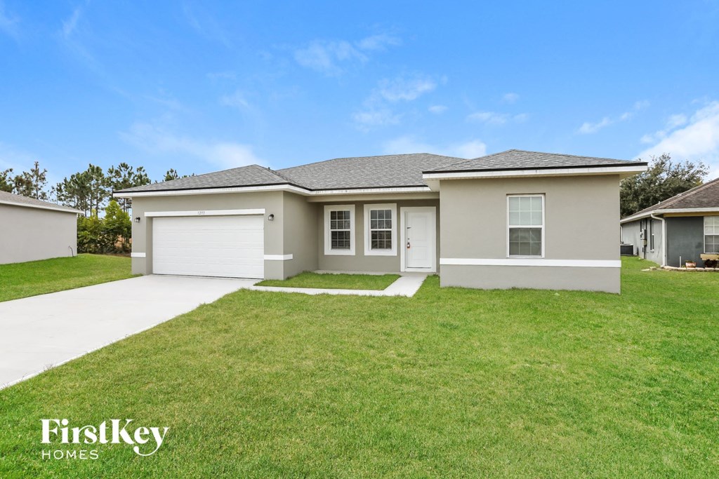 a beige house with a lawn in front of it