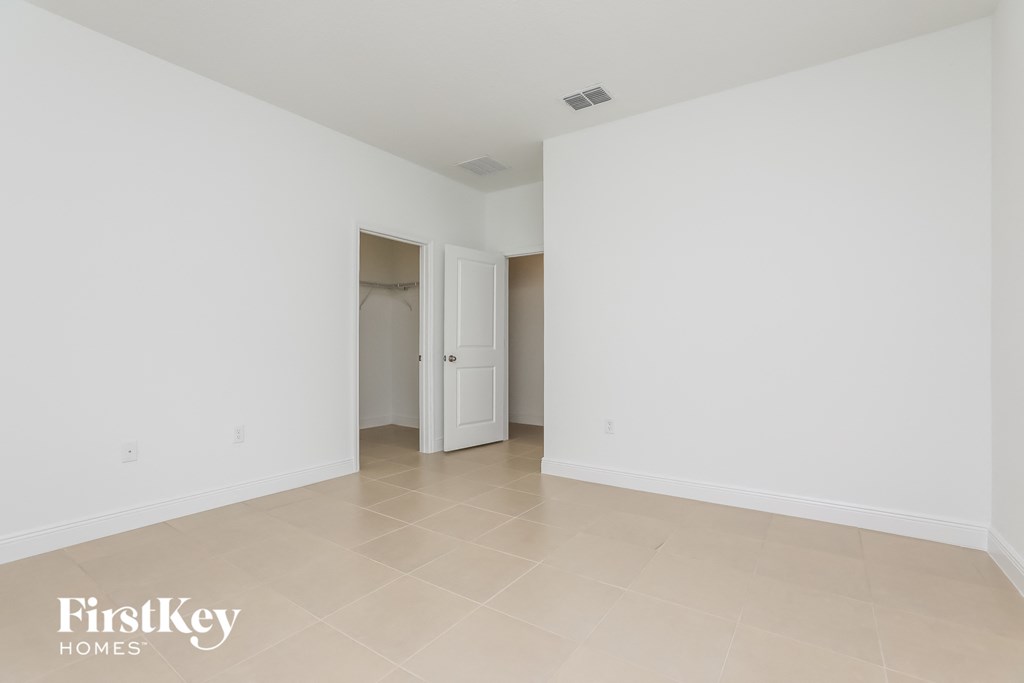 an empty living room with white walls and tiled floors