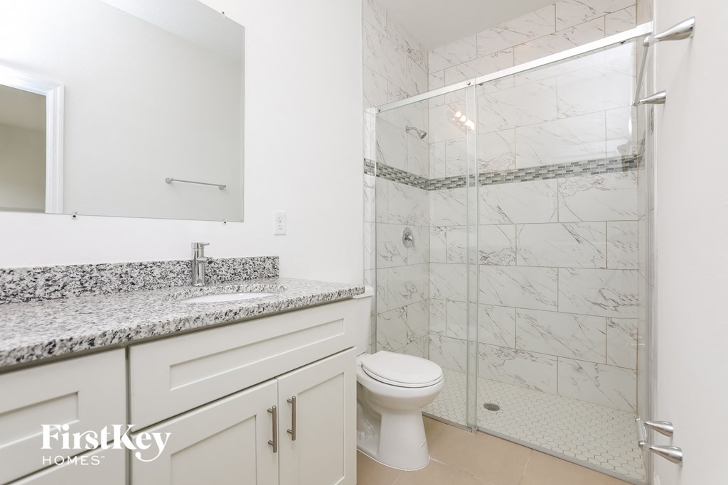 a bathroom with a shower and a sink and a toilet