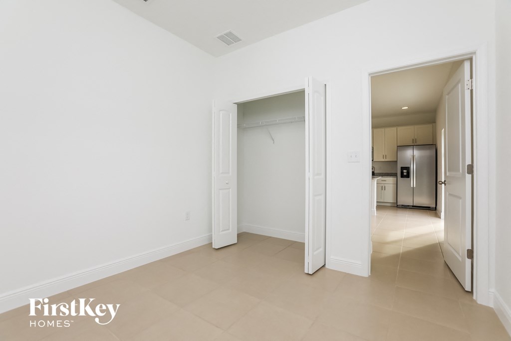 a living room with a door to a hallway and a kitchen