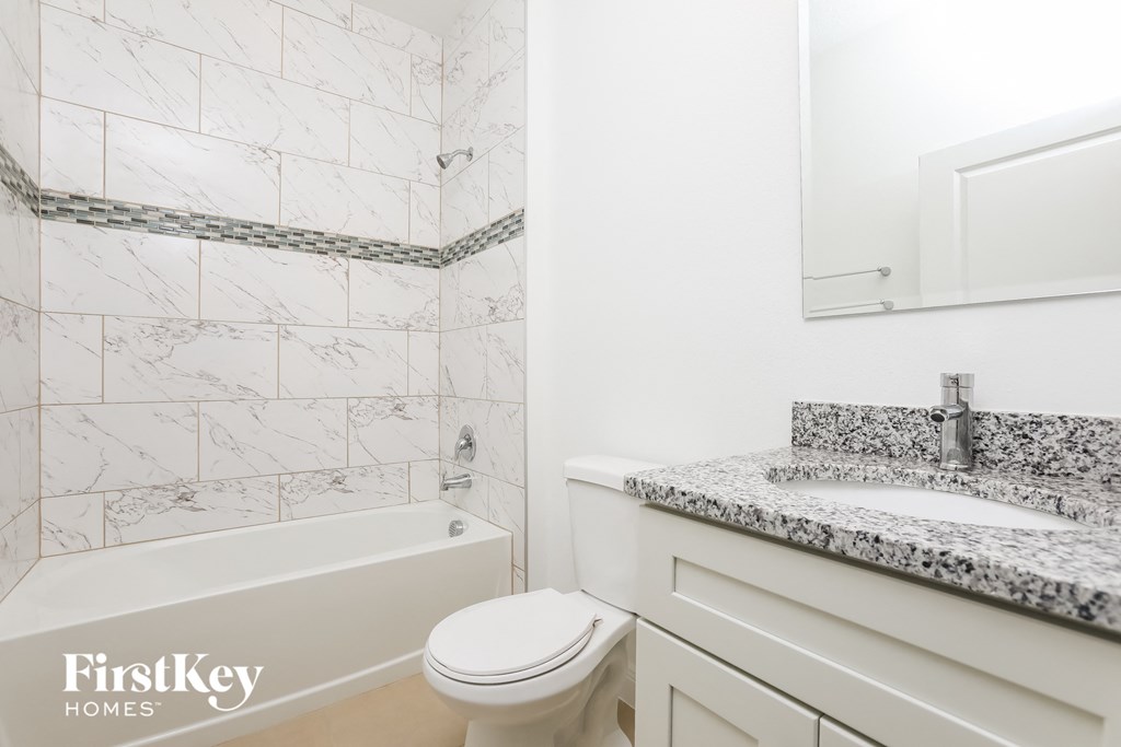 a bathroom with a toilet and a sink and a bath tub
