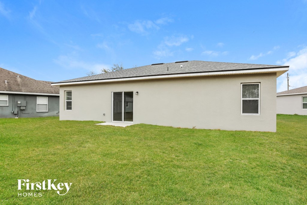 the backyard of a home with a green lawn and a white house