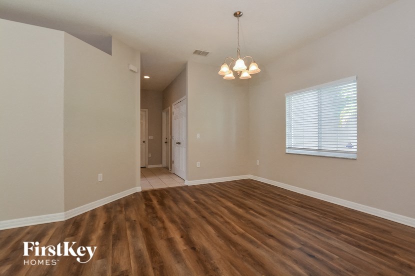an empty living room with wood flooring and a window
