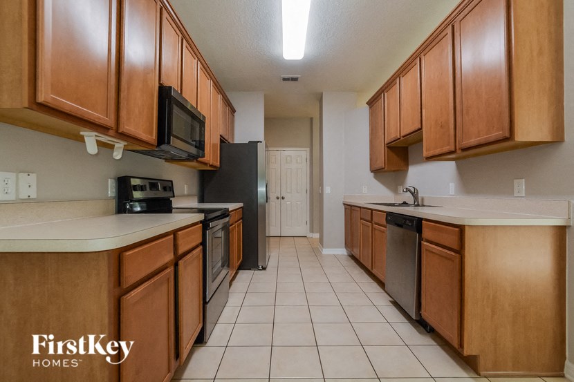 a kitchen with wooden cabinets and a stove and a microwave
