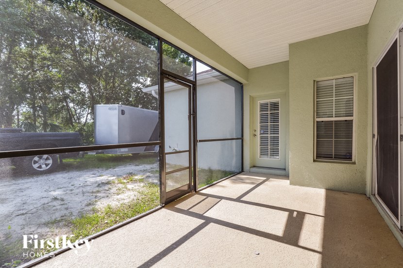 a porch with a glass door and a truck in the yard