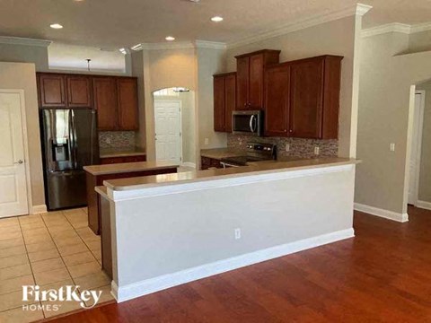 A kitchen with wooden cabinets and a white island.