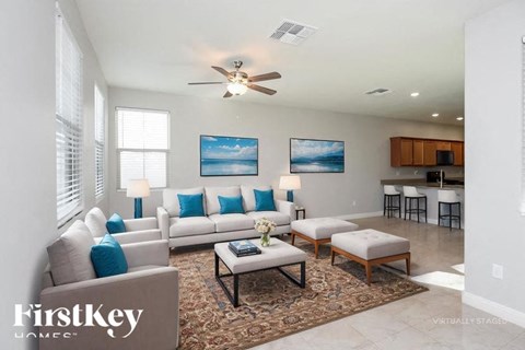 A living room with a couch, chairs, and a rug.