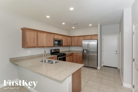 A kitchen with wooden cabinets and a granite countertop.