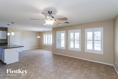 A spacious room with a ceiling fan and tiled floor.