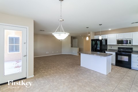 A kitchen with a black stove top oven and white cabinets.