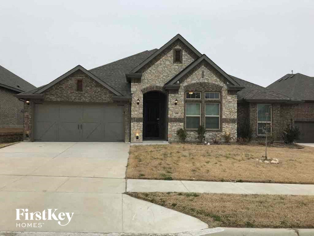 A house with a garage and a driveway in front of it.