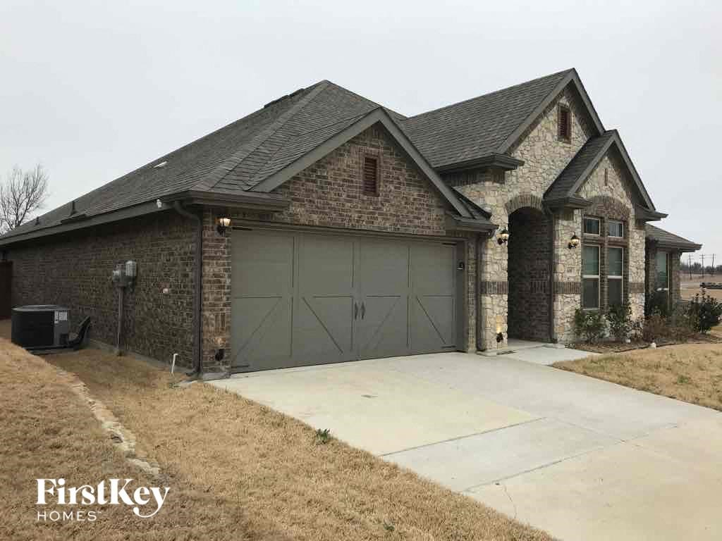 A house with a garage and a driveway in front of it.