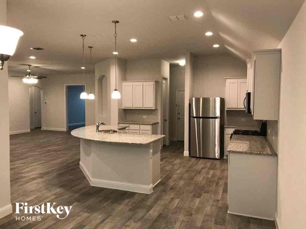 A kitchen with a white island and stainless steel appliances.