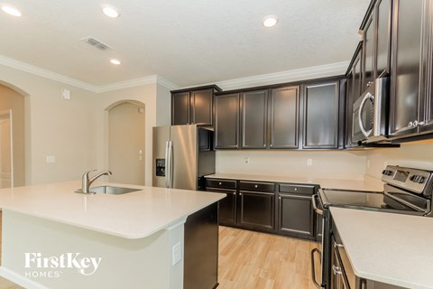 a kitchen with black cabinets and white counter tops and a sink