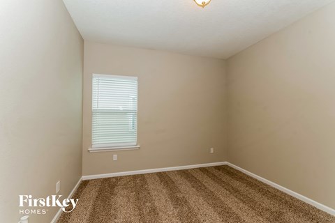 the upstairs bedroom with carpet and a large window