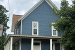 a blue house with white trim and a brown roof