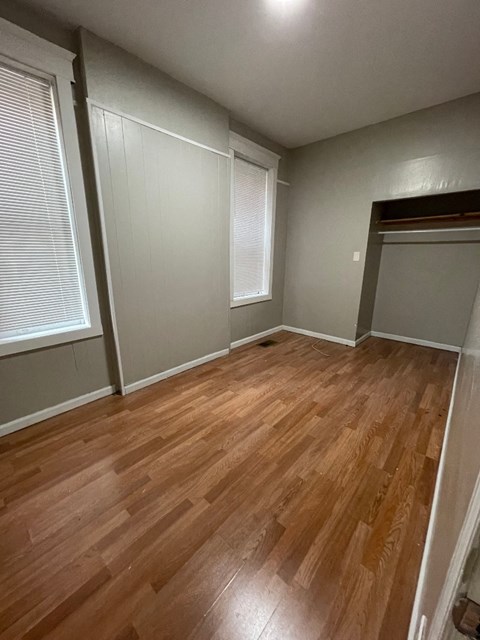 A room with wooden flooring and white walls.