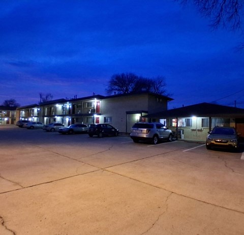 A parking lot with several cars and a building in the background.