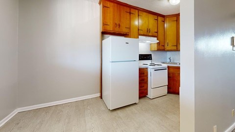 A kitchen with wooden cabinets and white appliances.
