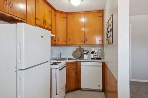 A kitchen with wooden cabinets and white appliances.