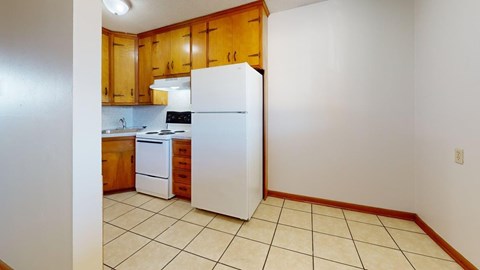 A kitchen with wooden cabinets and white appliances.