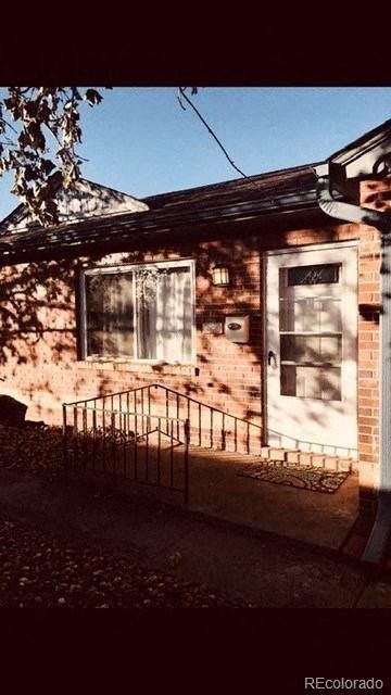 A small house with a metal fence in front.